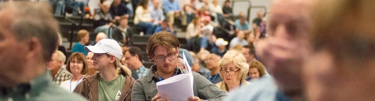 A voter reads the warrant during Town Meeting.
