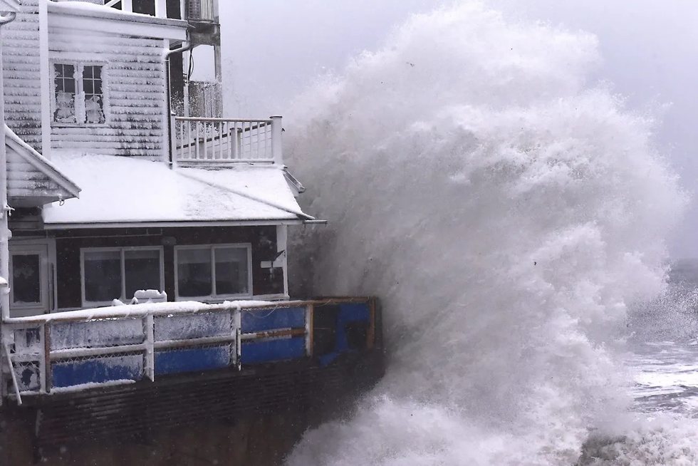 A wave breaks over The Barnacle restaurant during a blizzard.