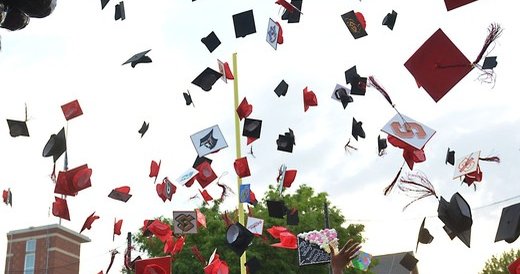 Graduation caps thrown in the air.