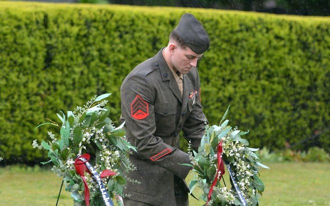 A Marine sergeant sets memorial wreaths on the green.