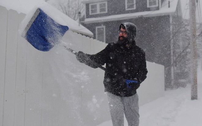 A man shovels snow during a winter storm.