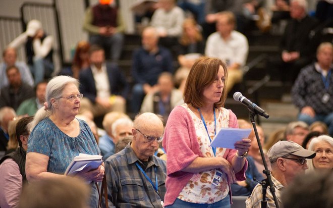 Jeanne Lambkin speaks at a microphone at Town Meeting.