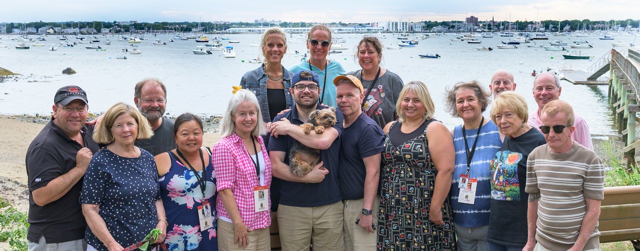 The news team gathered for a group photograph at a harbor picnic.